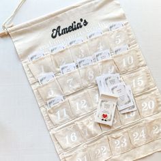 a calendar hanging on a white wall with numbers and magnets attached to the front