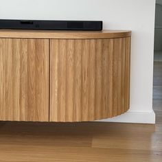 a large wooden cabinet sitting on top of a hard wood floor next to a white wall