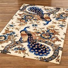 a rug with two peacocks on it in the middle of a wooden flooring area