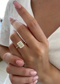 a woman's hand with a ring on it and a diamond in the middle