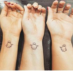 three people with matching wrist tattoos on their arms, one has a ghost and the other has a ghost