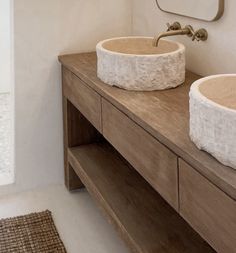 two wooden sinks sitting on top of a counter next to a wall mounted mirror in a bathroom