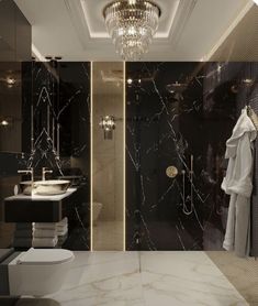 a bathroom with black marble walls and flooring, chandelier above the toilet