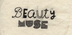 the word beauty is written in black ink on a piece of fabric that has been stitched into it