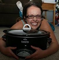 a woman laying on the floor holding an open crock pot