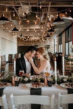 a bride and groom sitting at a dinner table