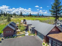 an aerial view of a home in the mountains with lots of green grass and trees