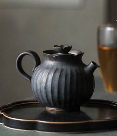 a black tea pot sitting on top of a tray