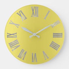 a yellow wall clock with roman numerals on the face and numbers painted white