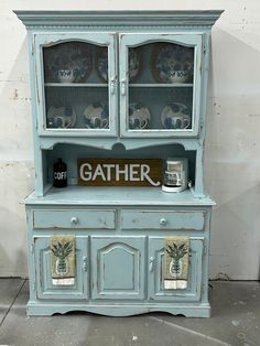 an old china cabinet painted blue with pineapple decals