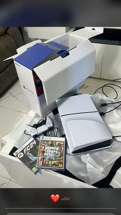 an open laptop computer sitting on top of a table next to a box and other items