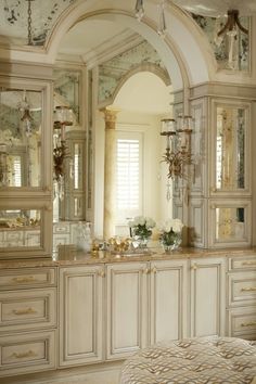 an ornate bathroom with white cabinets and marble counter tops