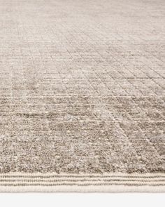 an area rug with squares and lines on the bottom in neutral colors, including beige