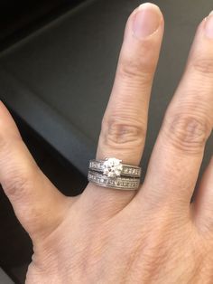 a person's hand with two wedding rings on top of their fingers and the middle finger