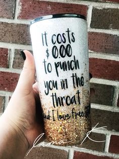 a hand holding a coffee cup with writing on it that says it cost $ 600 to punch you in the throat and i love free