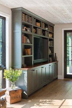 a large entertainment center with bookshelves and cabinets in the middle of a room