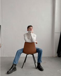 a man sitting on top of a brown chair