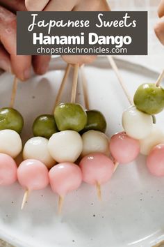 several skewers with green and pink toppings on top of a white plate