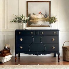 a black dresser with two vases on top of it