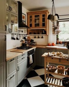 a kitchen with black and white checkered flooring next to a stove top oven