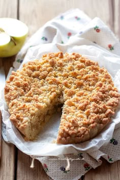 an apple pie with one slice cut out on a napkin next to the whole pie