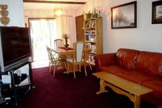 a living room filled with furniture and a flat screen tv on top of a wooden table