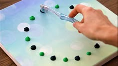 a person using a toothbrush to brush their teeth with green and black candies