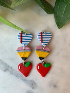 two heart shaped earrings on top of a table