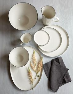 white dishes and cups are arranged on a table