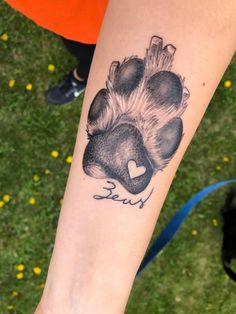 a person with a tattoo on their arm that has a bear's paw in the shape of a heart