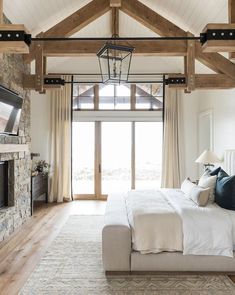 a bedroom with a large bed, fireplace and television in the middle of the room