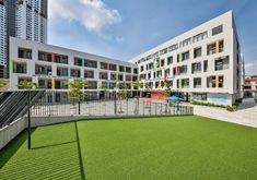 an empty playground in front of a building with lots of windows and balconies