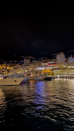 a large white boat floating on top of a body of water next to a city