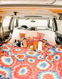 the back end of a van with an open trunk filled with food and snacks in it