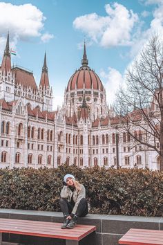 a person sitting on a bench in front of a building