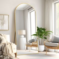 a living room filled with furniture and a large gold framed mirror on the wall next to a window