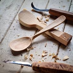 two wooden spoons are laying on the floor next to some wood shaving tools