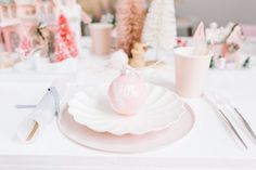 a white table topped with pink plates and silverware