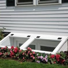 the window sill is made out of white wood and has flowers growing on it