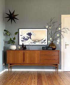 a living room scene with focus on the sideboard and vases in the foreground