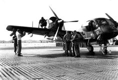 men standing around an airplane on the tarmac