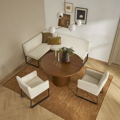 an overhead view of a living room with white couches, chairs and a round coffee table