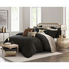 a bed with black and tan comforters in a room