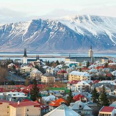 a city with mountains in the background and snow on the top of it's peaks