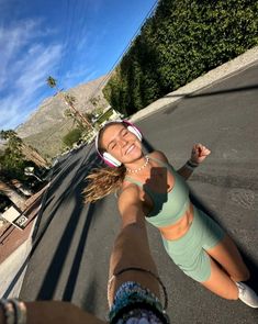 a woman is taking a selfie in the middle of the street with her headphones on