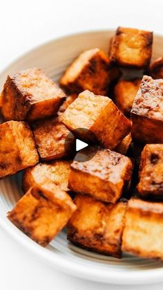 a white plate topped with tofu cubes on top of a table