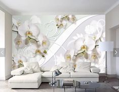 a living room with white furniture and flowers on the wall