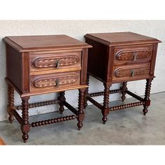 two wooden nightstands sitting next to each other on top of a cement floor in front of a wall