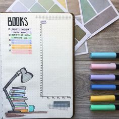 an open notebook with books and markers on it