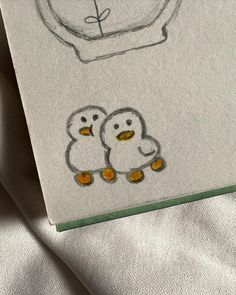 a drawing of two little penguins sitting next to each other on a sheet of paper